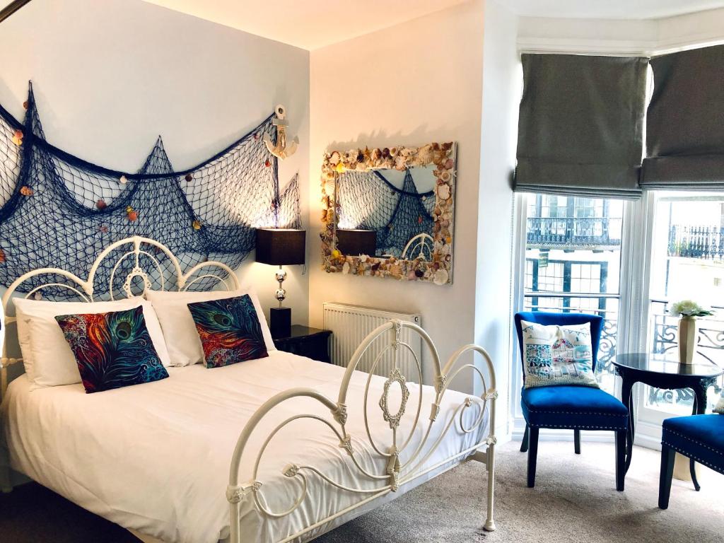 ブライトン＆ホーブにあるGrand Pier Guest Houseのベッドルーム1室(ベッド1台、青い椅子付)