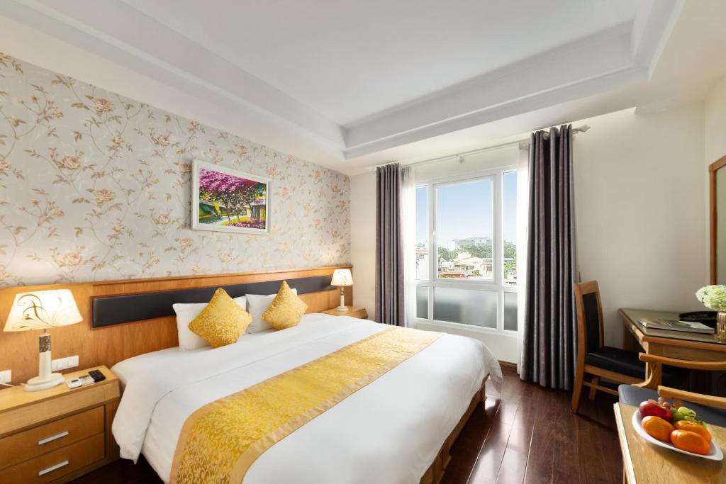 um quarto de hotel com uma cama grande e uma janela em Hanoi Sky Hotel em Hanói