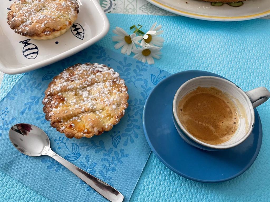 una mesa azul con una taza de café y dos donuts en B&B MimmoSole, en Agropoli