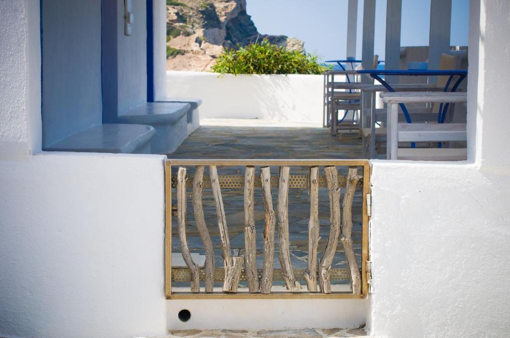 a balcony with chairs and tables on a building at Κymanemi Folegandros in Agali