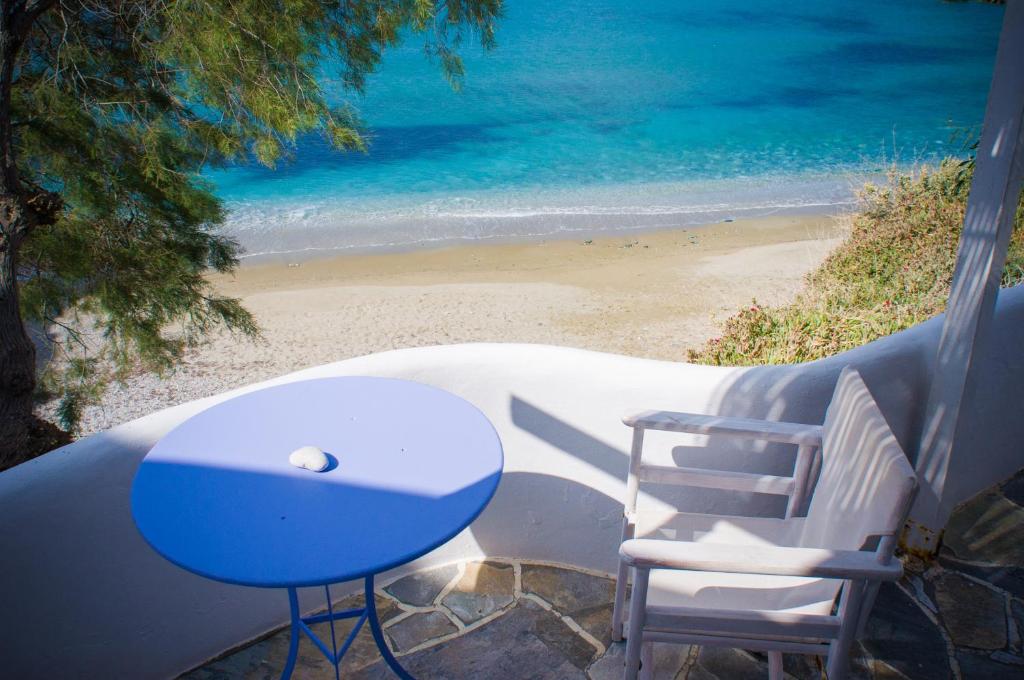 a table and chairs sitting on a balcony overlooking the beach at Κymanemi Folegandros in Agali