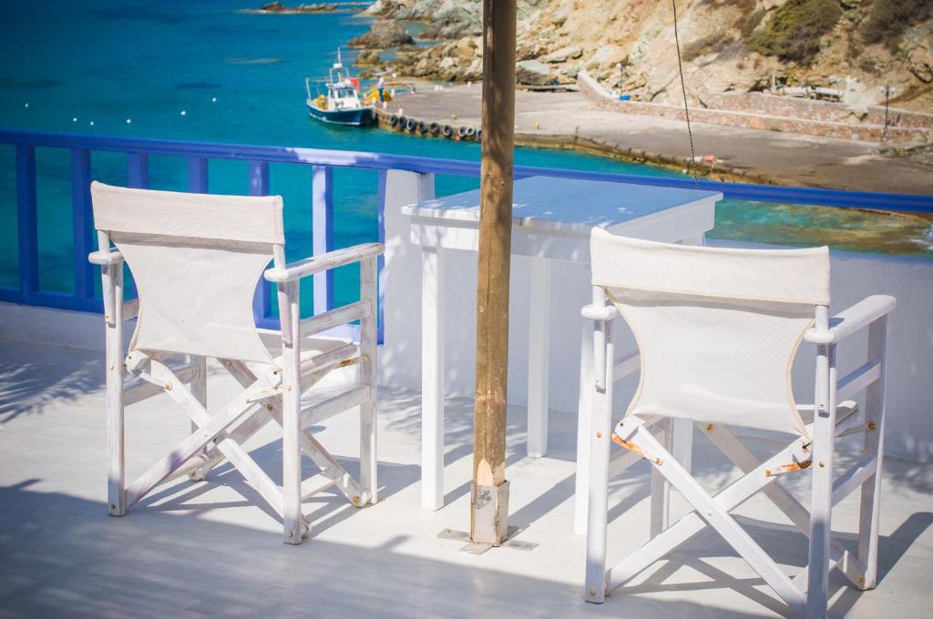 two white chairs sitting on a porch overlooking the water at Κymanemi Folegandros in Agali