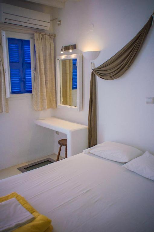 a bedroom with a bed and a desk and a window at Κymanemi Folegandros in Agali