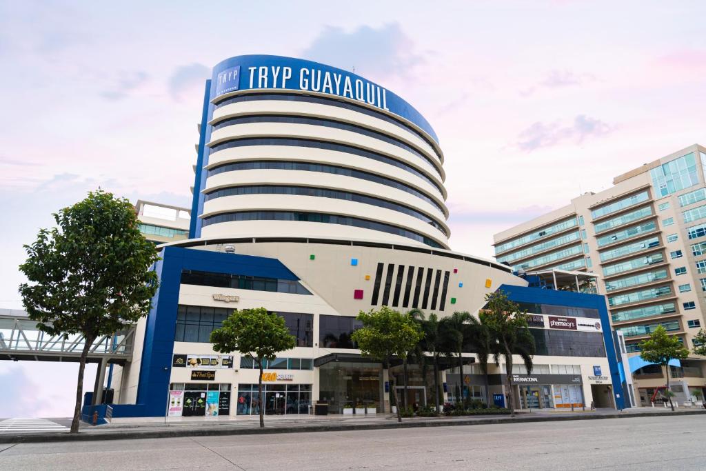 un gran edificio con un cartel encima en TRYP by Wyndham Guayaquil Airport, en Guayaquil