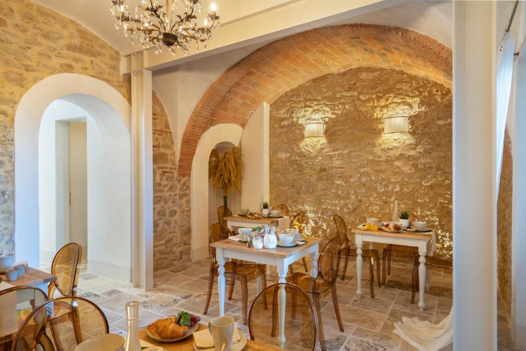 un ristorante con due tavoli e un muro di pietra di Beatabb a Guardistallo