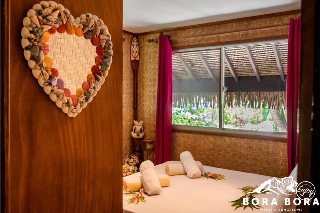a heart decoration on a wall next to a bed at Villa Bora Bora - on Matira in Bora Bora