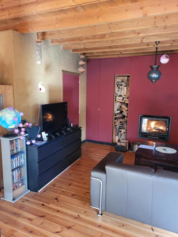 sala de estar con sofá y TV en Purple Papillon, en Heuvelland