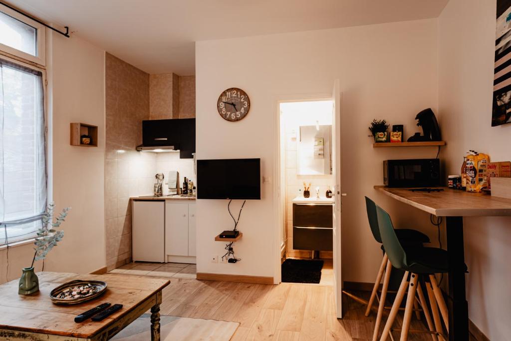 Ce petit appartement comprend une cuisine et une table. dans l'établissement Les Appartements Hyper Centre Valenciennes, à Valenciennes