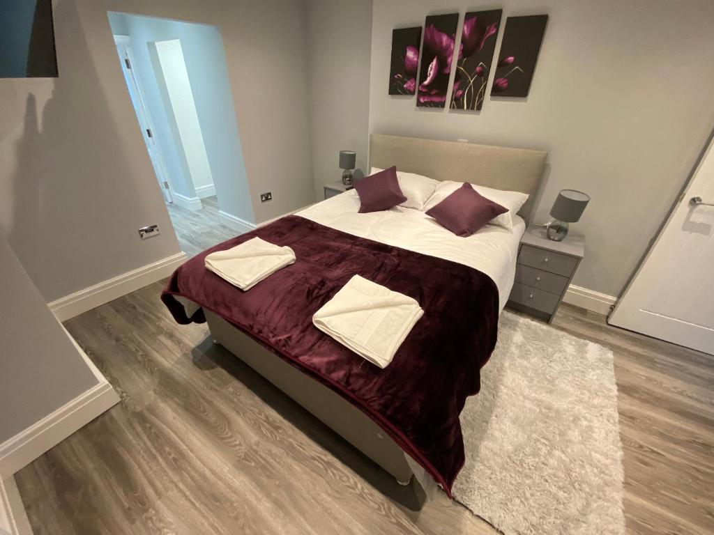 Un dormitorio con una cama grande con sábanas y almohadas púrpuras. en Edward Place Luxury Hot Tub Apartments en Blackpool