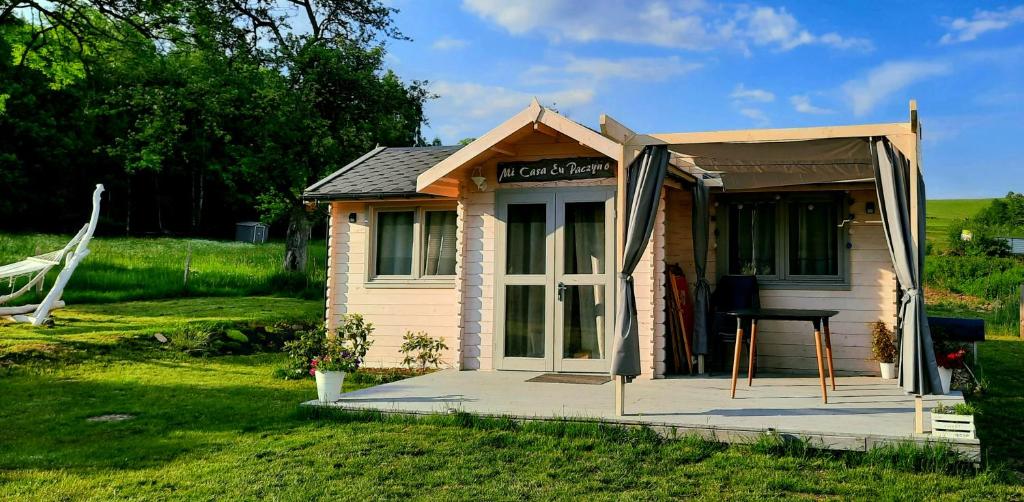 a small shed with a porch and a table outside at Mi Casa En Paczyno in Lubawka