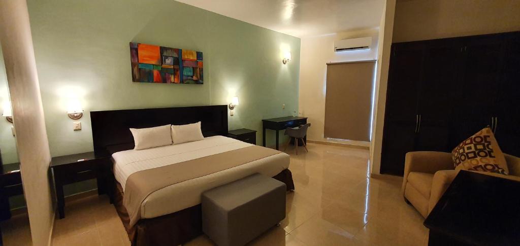 a hotel room with a bed and a couch at Hotel Arribo in Lagos de Moreno