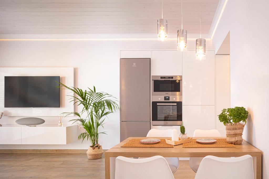 cocina con mesa de madera y sillas blancas en ETHOS Luxury Home - Seaview Villa with Hot-Tub! en Iraion
