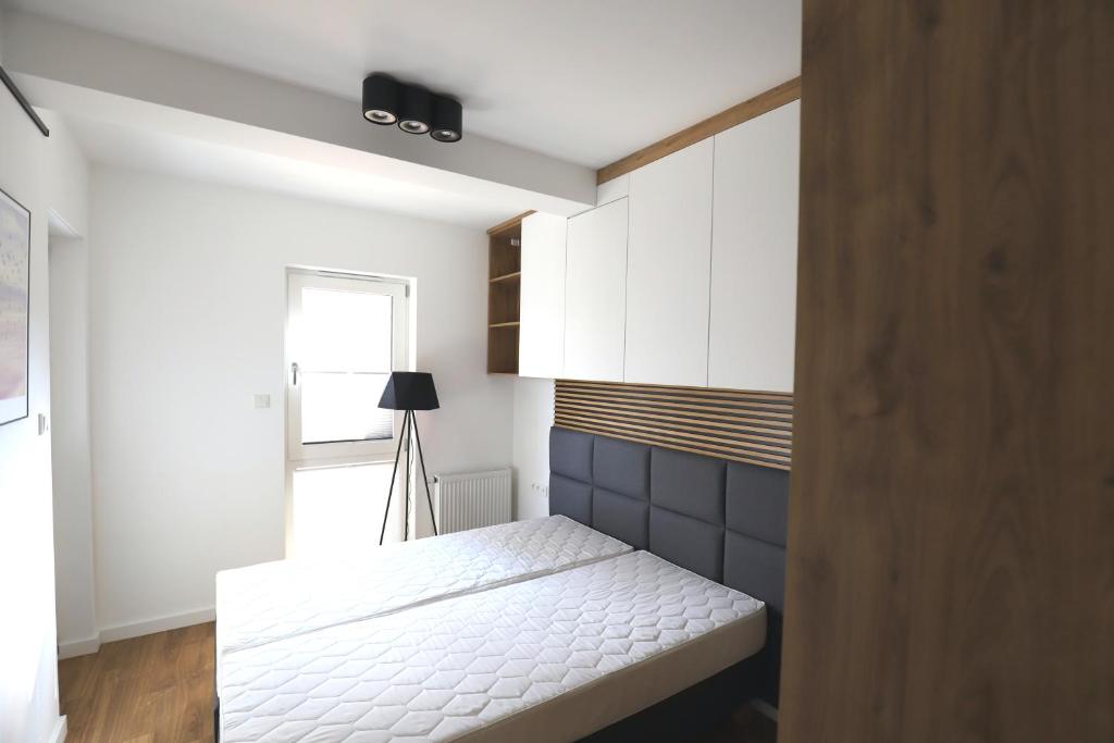 A bed or beds in a room at Nowe kameralne Apartamenty Graniczna2G Niechorze - sosnowy las i bardzo blisko plaży