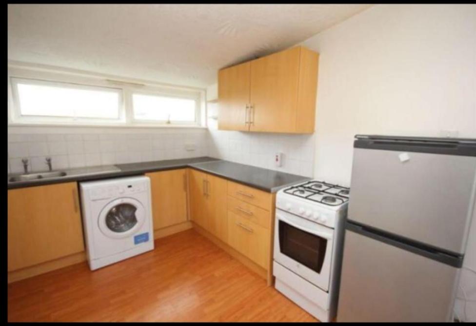 uma cozinha com um fogão branco forno superior junto a uma máquina de lavar roupa em Bathgate Handy House em Bathgate