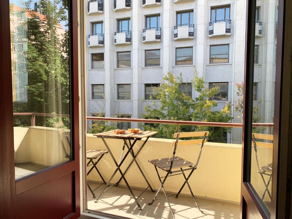 einen Balkon mit einem Tisch und Stühlen sowie ein Gebäude in der Unterkunft Pinpoint Porto Apartment by Porto City Hosts in Porto