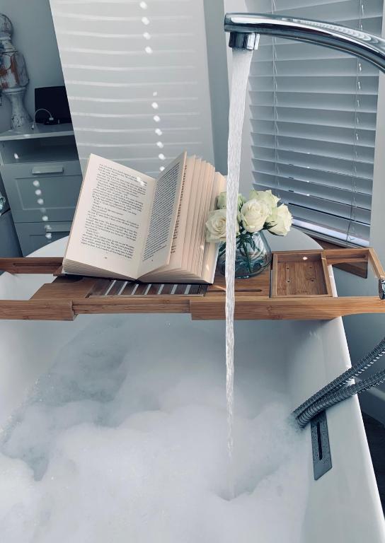 a book sitting on a table with water pouring at Sandy feet retreat in Exmouth