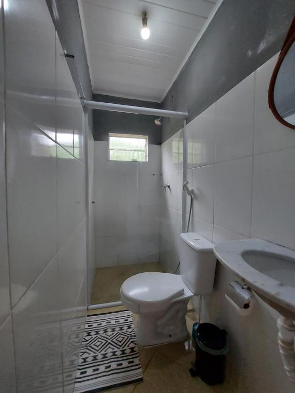 a bathroom with a toilet and a shower and a sink at Chalé Recanto Das Saíras em Paraty in Paraty