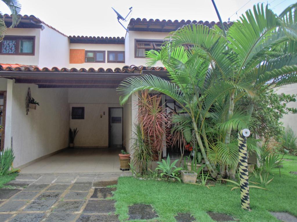 a house with palm trees in front of it at EXCELENTE CASA EM CABO FRIO - BRAGA in Cabo Frio