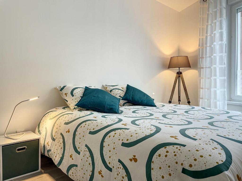 een slaapkamer met een bed met blauwe kussens bij EM LIFE COLMAR in Colmar