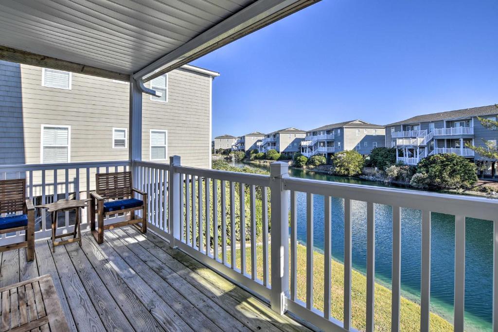 a balcony with two benches and the water at Sunny Condo - Private Ocean Isle Beach Access! in Ocean Isle Beach
