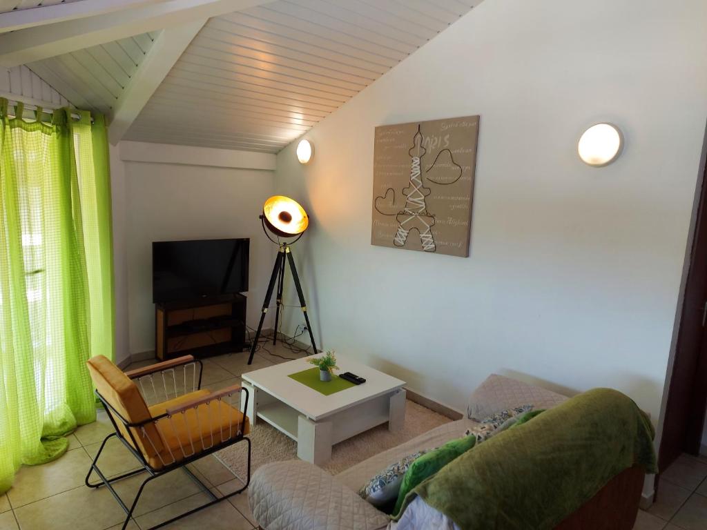 uma sala de estar com um sofá e uma televisão em NANA - A 44 - Vue Panoramique-Appartement Cosy et Lumineux- Cuisine équipée- - Centre Ville-WIFI-CLIM- NETFLIX - Parking public gratuit-Garage privé payant em Caiena