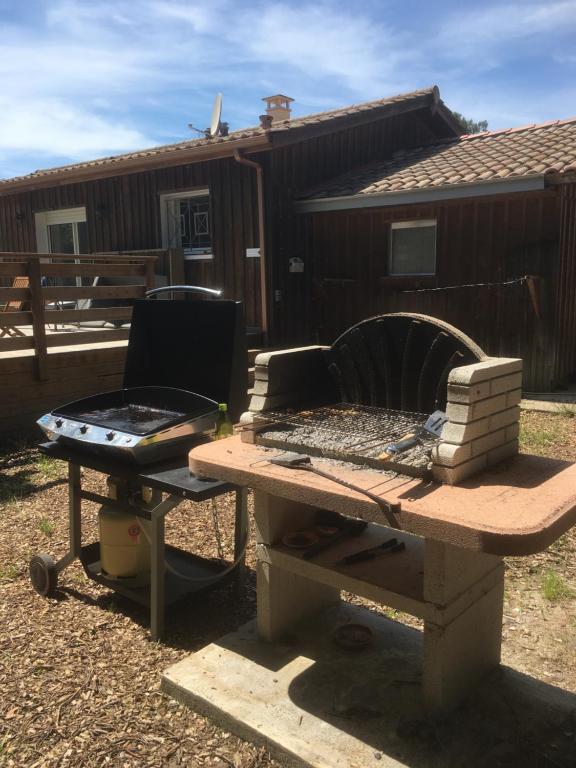 a picnic table with a grill and a grill at comme chez vous in Taussat-les-Bains