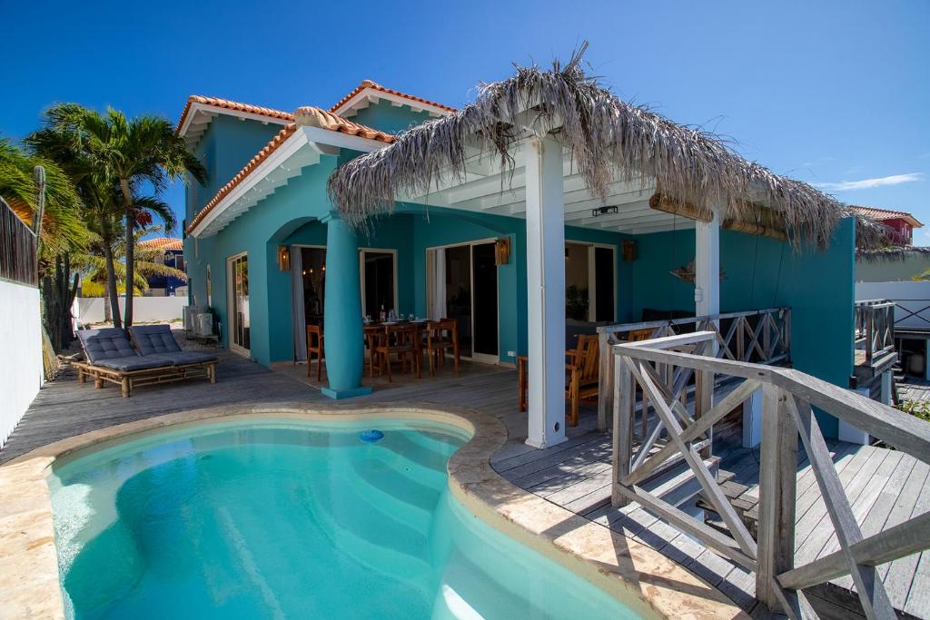 a villa with a swimming pool and a house at Kas Sumba in Water Villas in Kralendijk