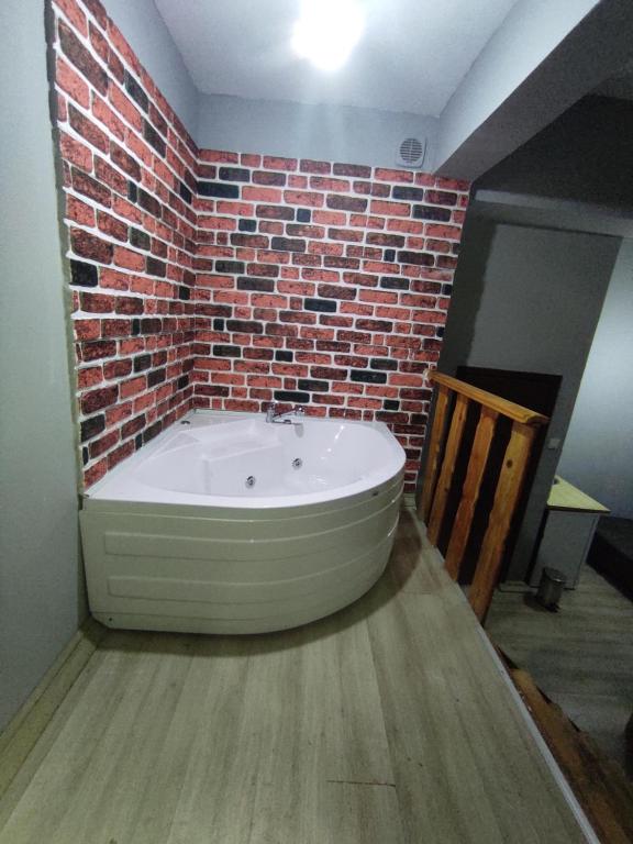 uma banheira num quarto com uma parede de tijolos em paşa konağı konaklama em Ancara