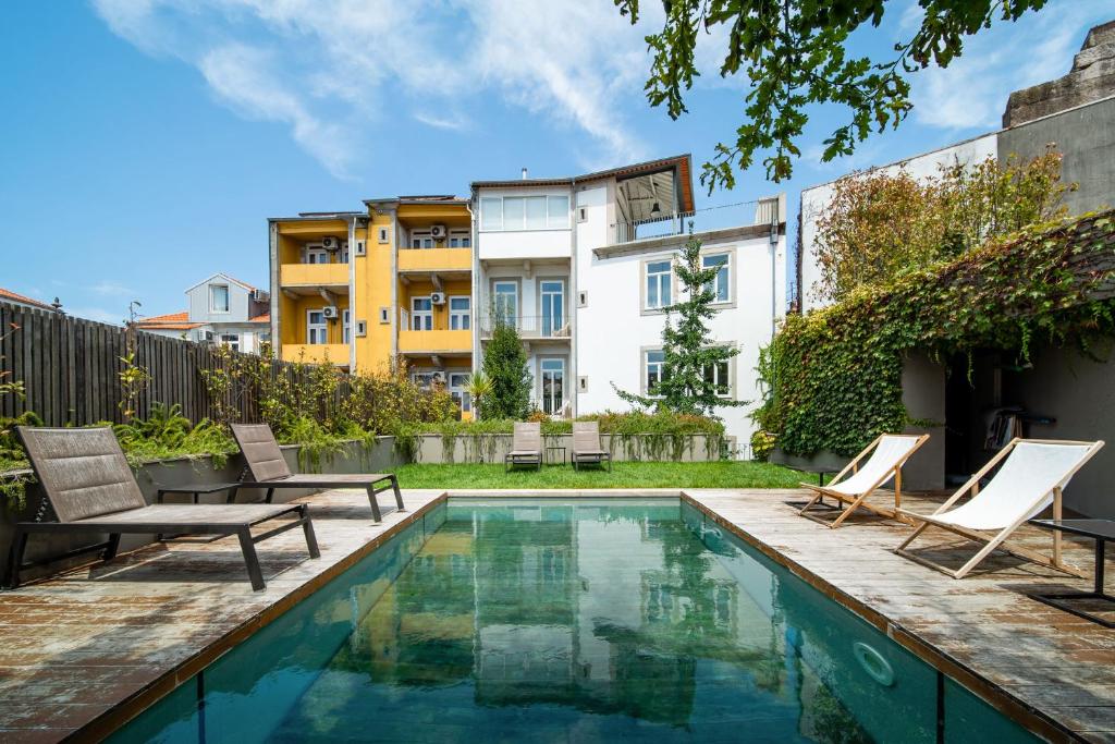 una piscina en el patio trasero con sillas y un aro de baloncesto en Casa do Cativo en Oporto