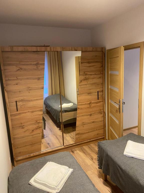 uno specchio in una stanza con un letto e una camera da letto di Bengal Apartments a Stettino