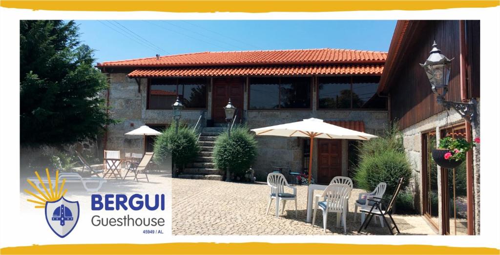 uma casa com cadeiras e guarda-sóis em frente em BERGUI Guesthouse - Guimarães em Guimarães
