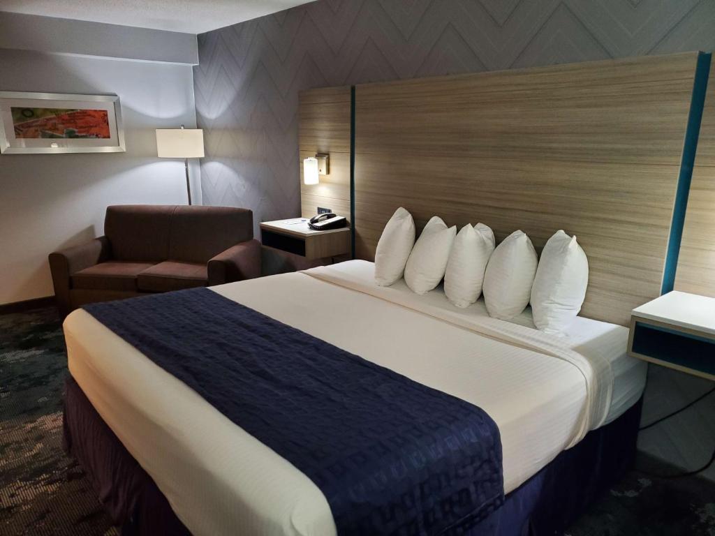 a hotel room with a large bed and a chair at Best Western Historic Frederick in Frederick