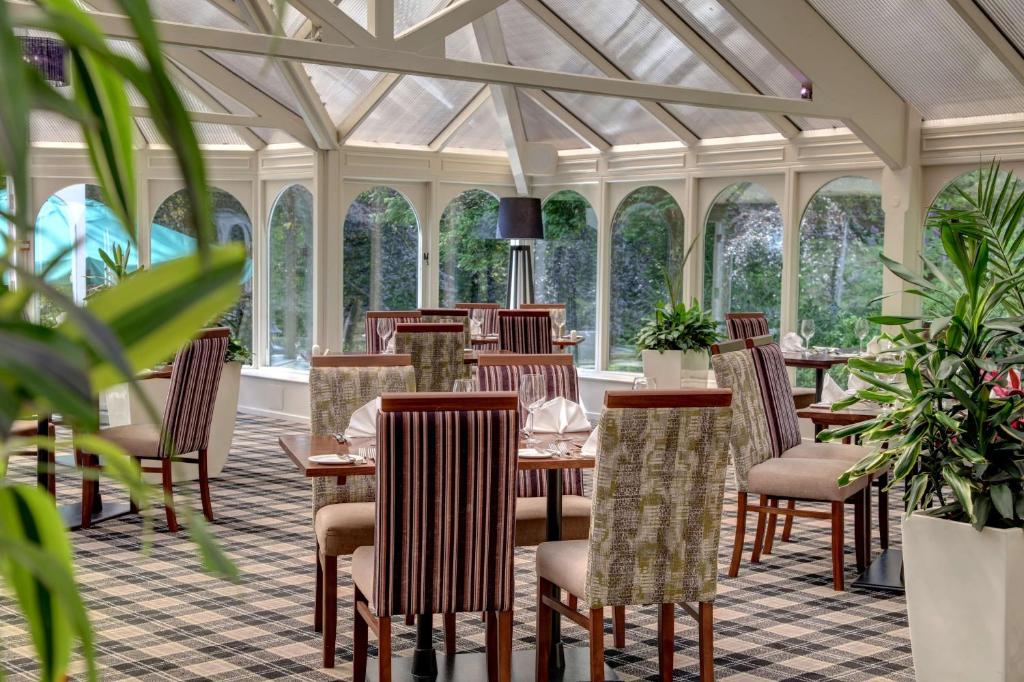 - une salle à manger avec des tables, des chaises et des fenêtres dans l'établissement B/W Plus Buxton Lee Wood Hotel, à Buxton