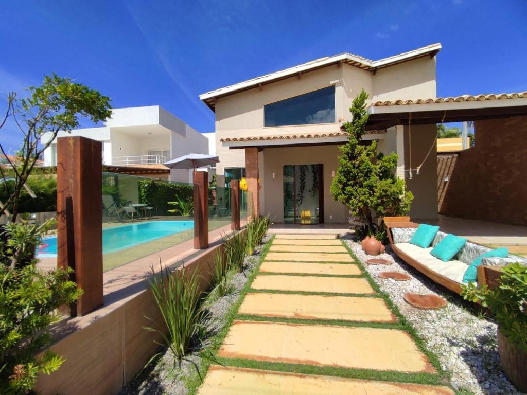 a villa with a swimming pool and a house at Linda casa de praia em Aracaju! in Aracaju
