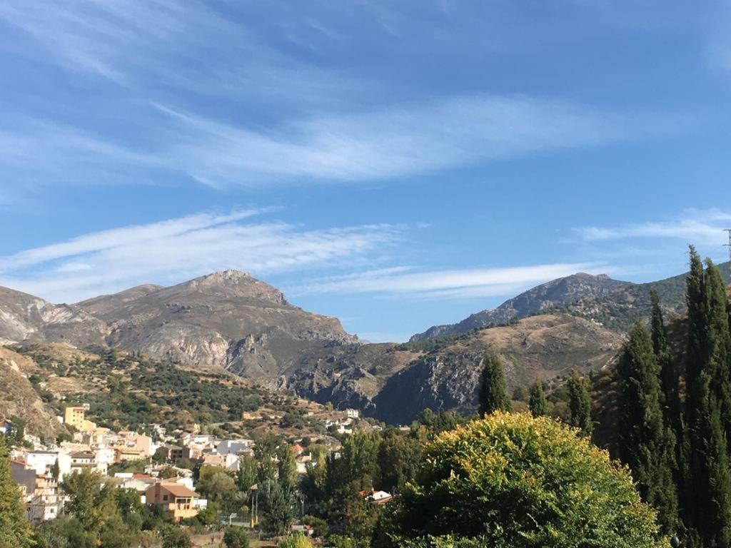 vista para uma cidade num vale com montanhas em Apartamento en Monachil pueblo em Monachil