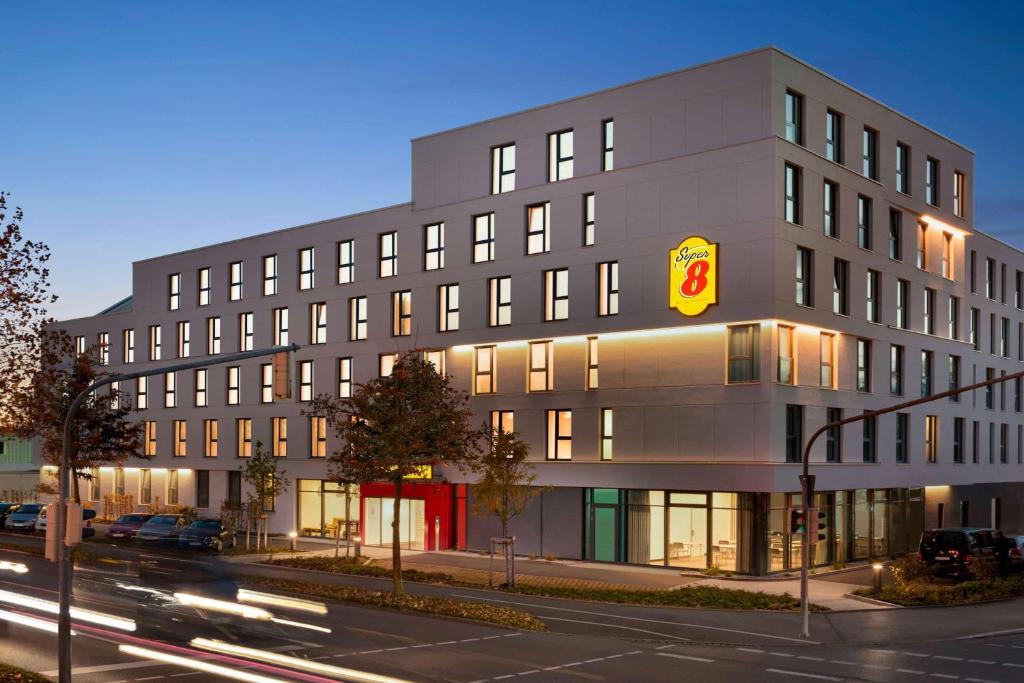 a large building with a fast food restaurant sign on it at Super 8 by Wyndham Augsburg in Augsburg