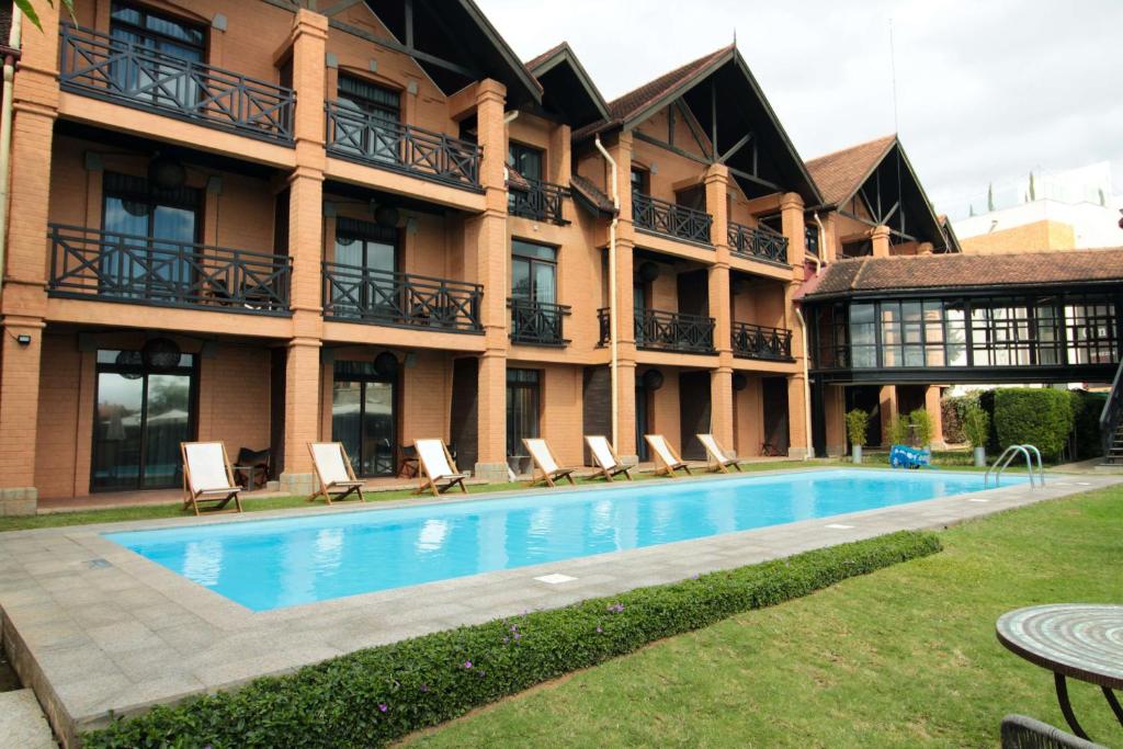 ein Hotel mit einem Pool vor einem Gebäude in der Unterkunft Radisson Hotel Tamboho Waterfront Antananarivo in Antananarivo