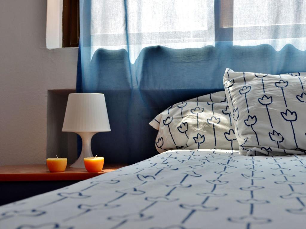 Roomin Hostel في سلامنكا: غرفة نوم بسرير ومصباح وستارة زرقاء