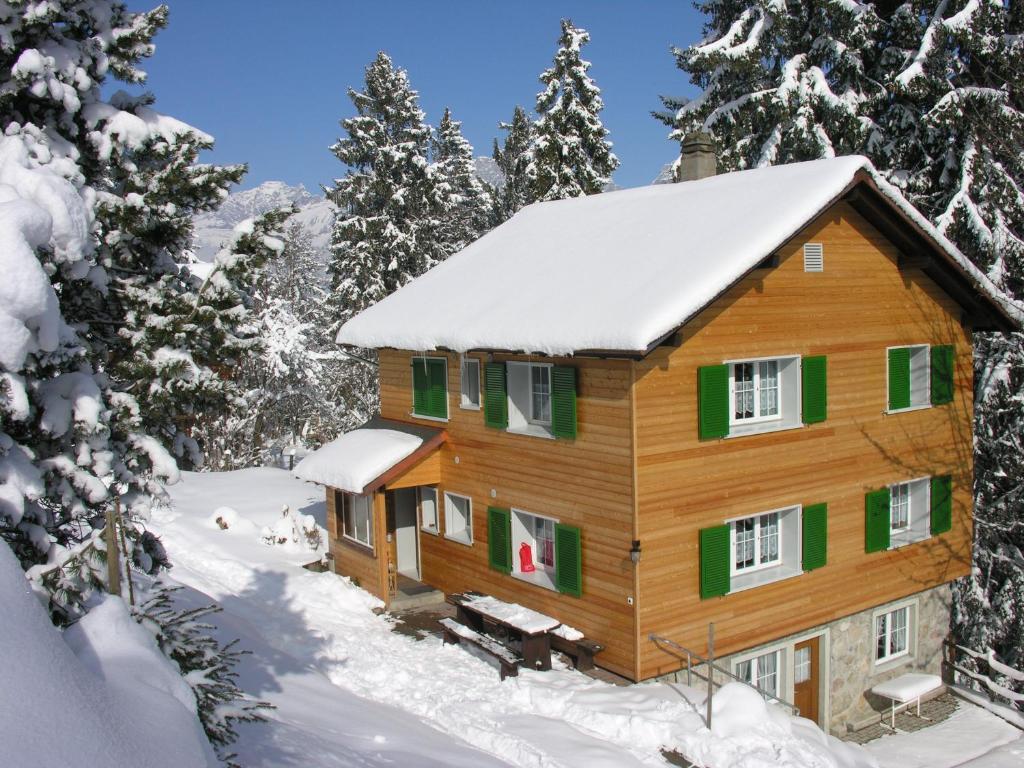 een blokhut in de sneeuw met bomen bij Chalet Good in Flumserberg