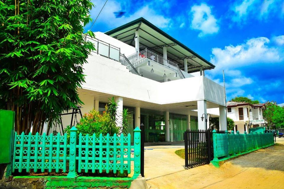 una casa blanca con una valla verde delante de ella en Hotel Green View Buttala en Buttala