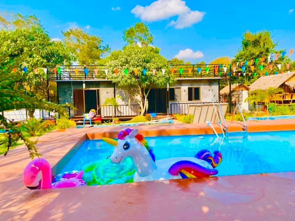 a pool with a plastic unicorn toy in front of a house at บ้านเดอะเมาเท่น By The Mountain Ozoneบ้านโอโซนขุนเขาแก่งกระจาน in Ban Song Phi Nong