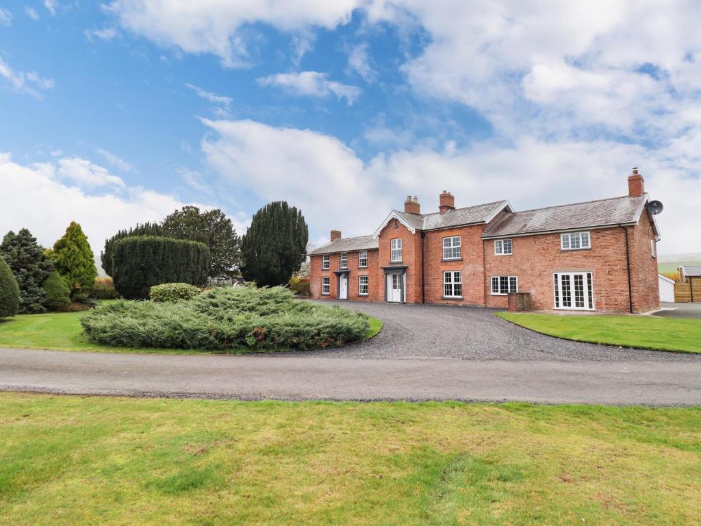 an old red brick house with a driveway at Bodaioch Hall in Caersws