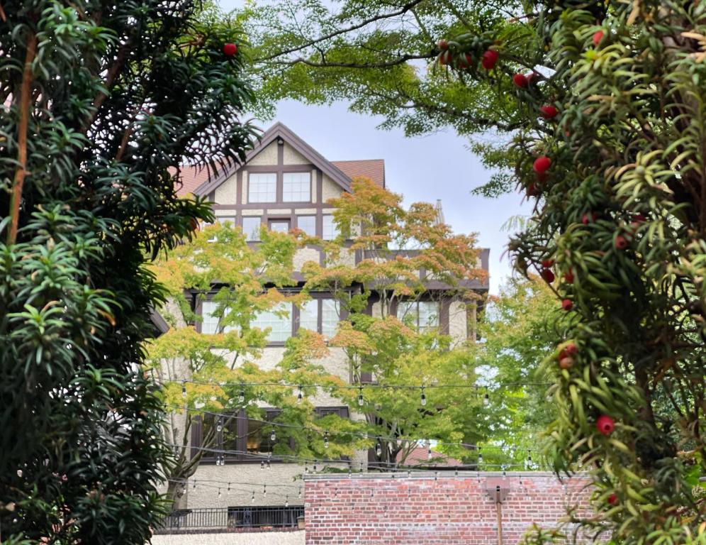 una casa a través de los árboles frente a una pared de ladrillo en Cecil Bacon Manor en Seattle