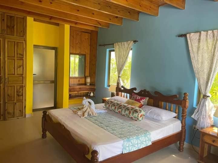 a dog sitting on a bed in a bedroom at Linsen Selfcatering Apartments in La Digue