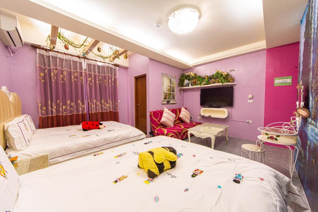 two beds in a room with purple walls at Sunflower B&amp;B II in Hualien City