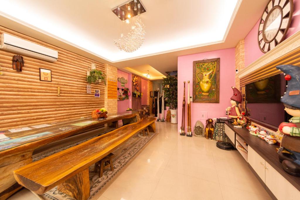 a hallway with a bench in a room with pink walls at Sunflower B&amp;B II in Hualien City
