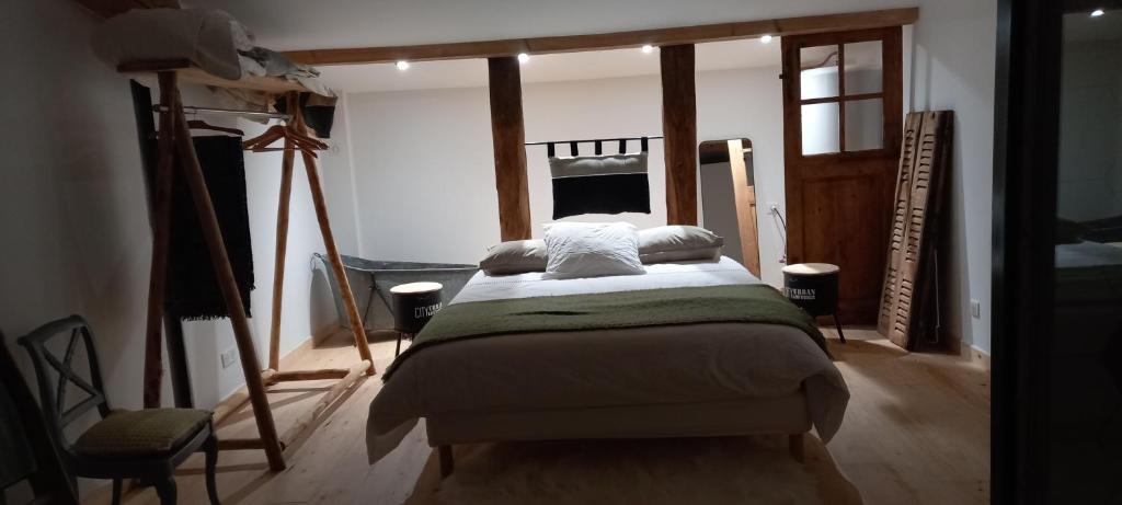 ein Schlafzimmer mit einem Bett in einem Zimmer in der Unterkunft GITE BUCOLIQUE LES RONZIERES in Saint-Paul-dʼUzore