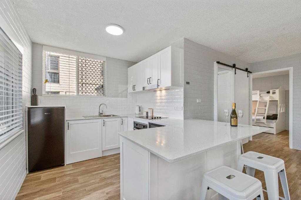 a kitchen with white cabinets and a white counter top at Sea-Hi Beachside Apartment in Maroochydore