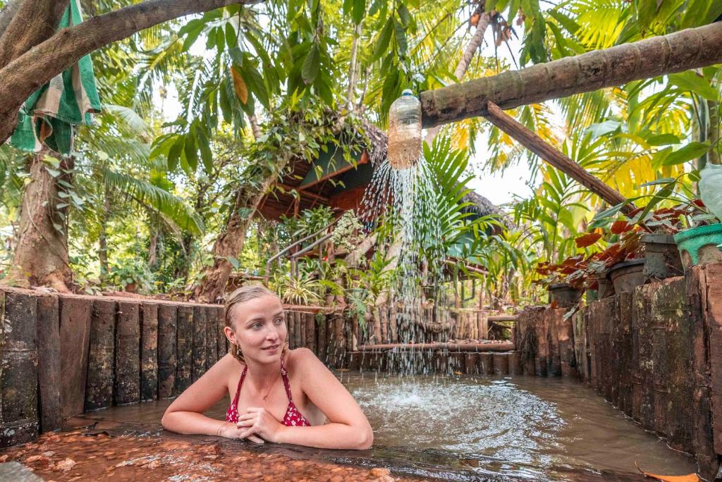 a young girl laying in a bath in a pool of water at Brookline Safari Resort in Udawalawe