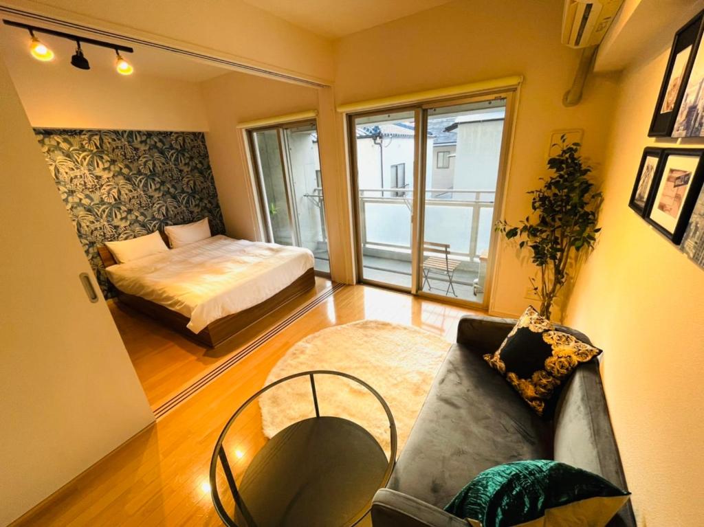 - un salon avec un lit et un canapé dans l'établissement Airstar Haruyoshi x Cube Haruyoshi Patio - Apartment stay, à Fukuoka